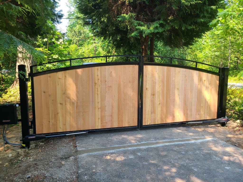 Arched double driveway gate with wood infill in a metal frame