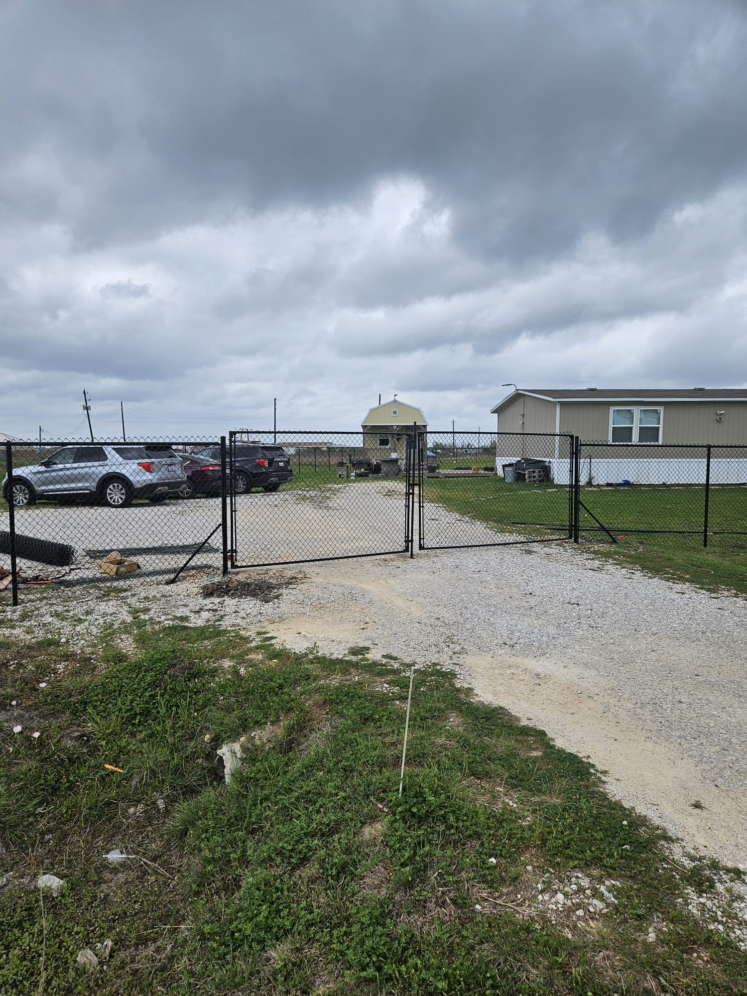 Chain link fence and gate across a gravel commercial lot