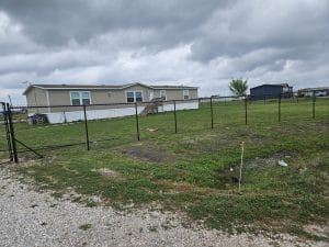 Chain link fence enclosing an open lot beside a single-storey building