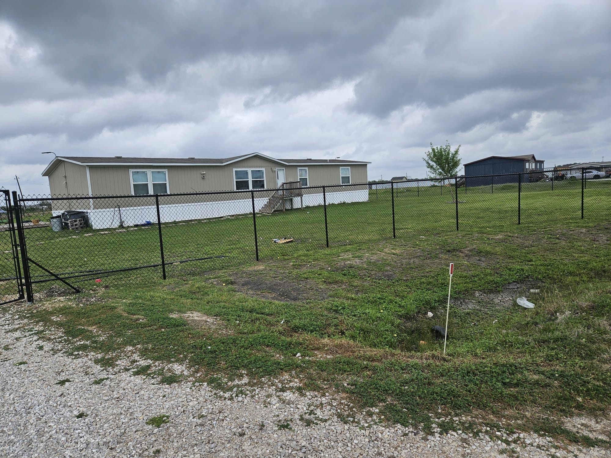 Chain link fence enclosing an open lot beside a single-storey building