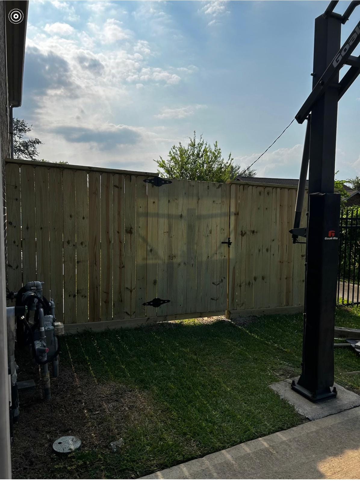 Solid wood privacy fence photographed at dusk beside equipment