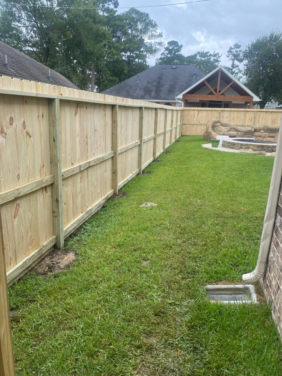 Wood privacy fence running the length of a back lawn