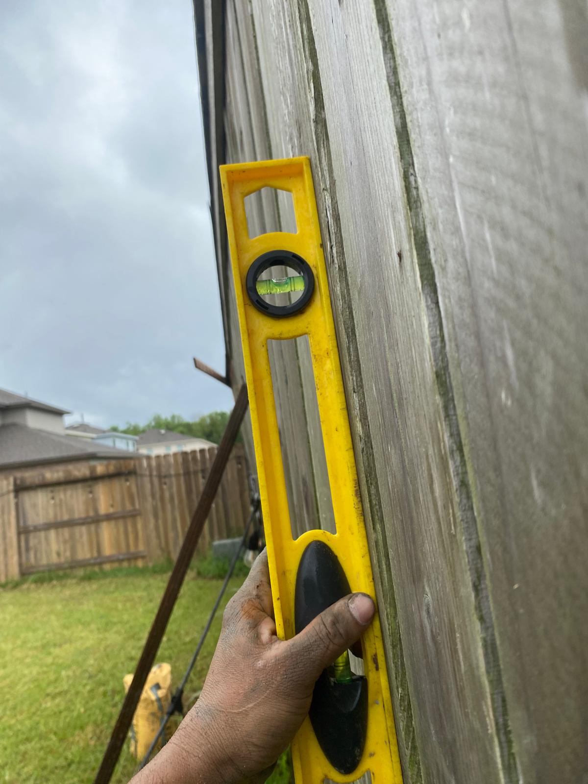 Installer checking a fence post with a spirit level