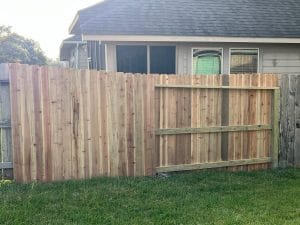 Wood privacy fence and gate beside a single-storey house