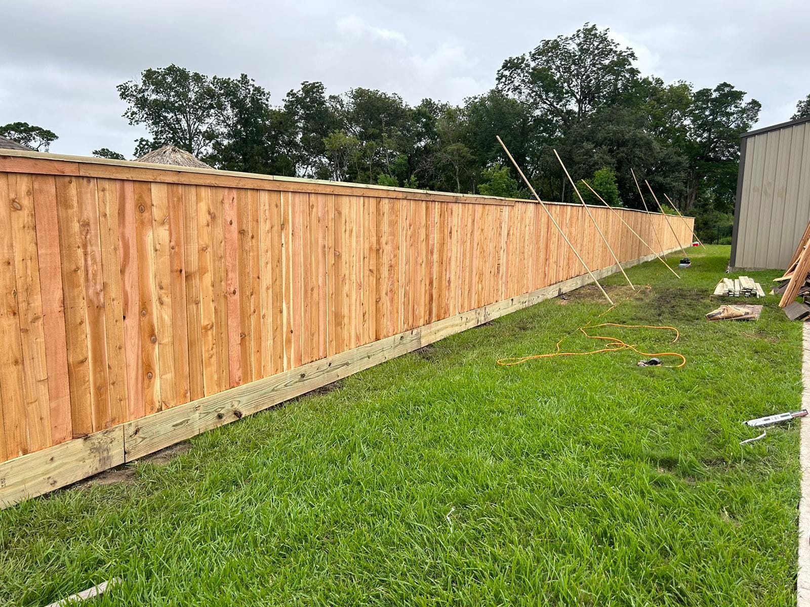 Long new wood fence with temporary bracing during installation
