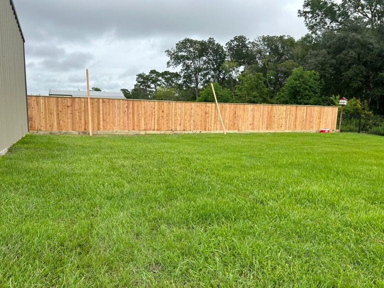 Long wood privacy fence enclosing a large open lawn