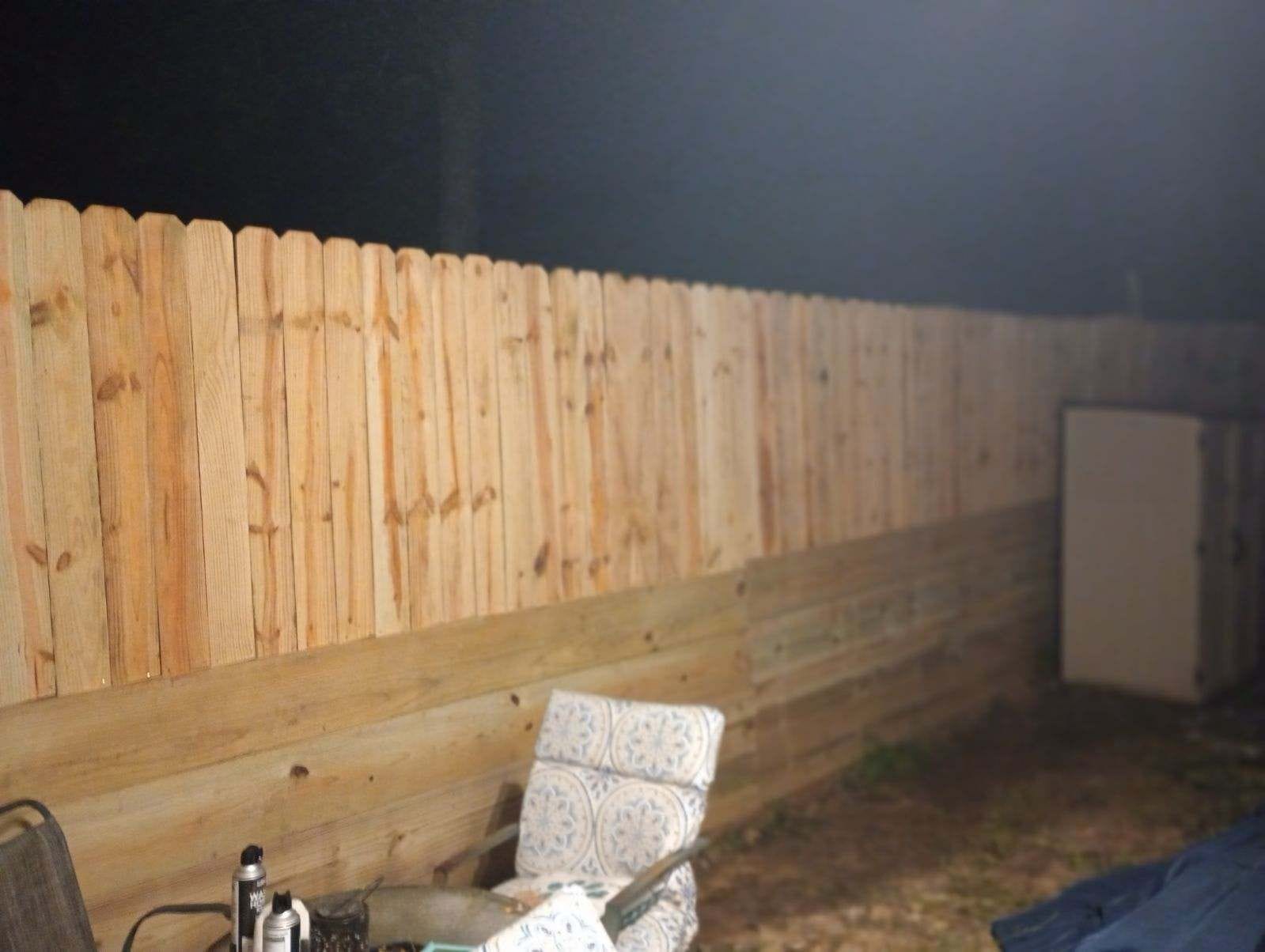 Interior corner of a wood privacy fence beside patio seating