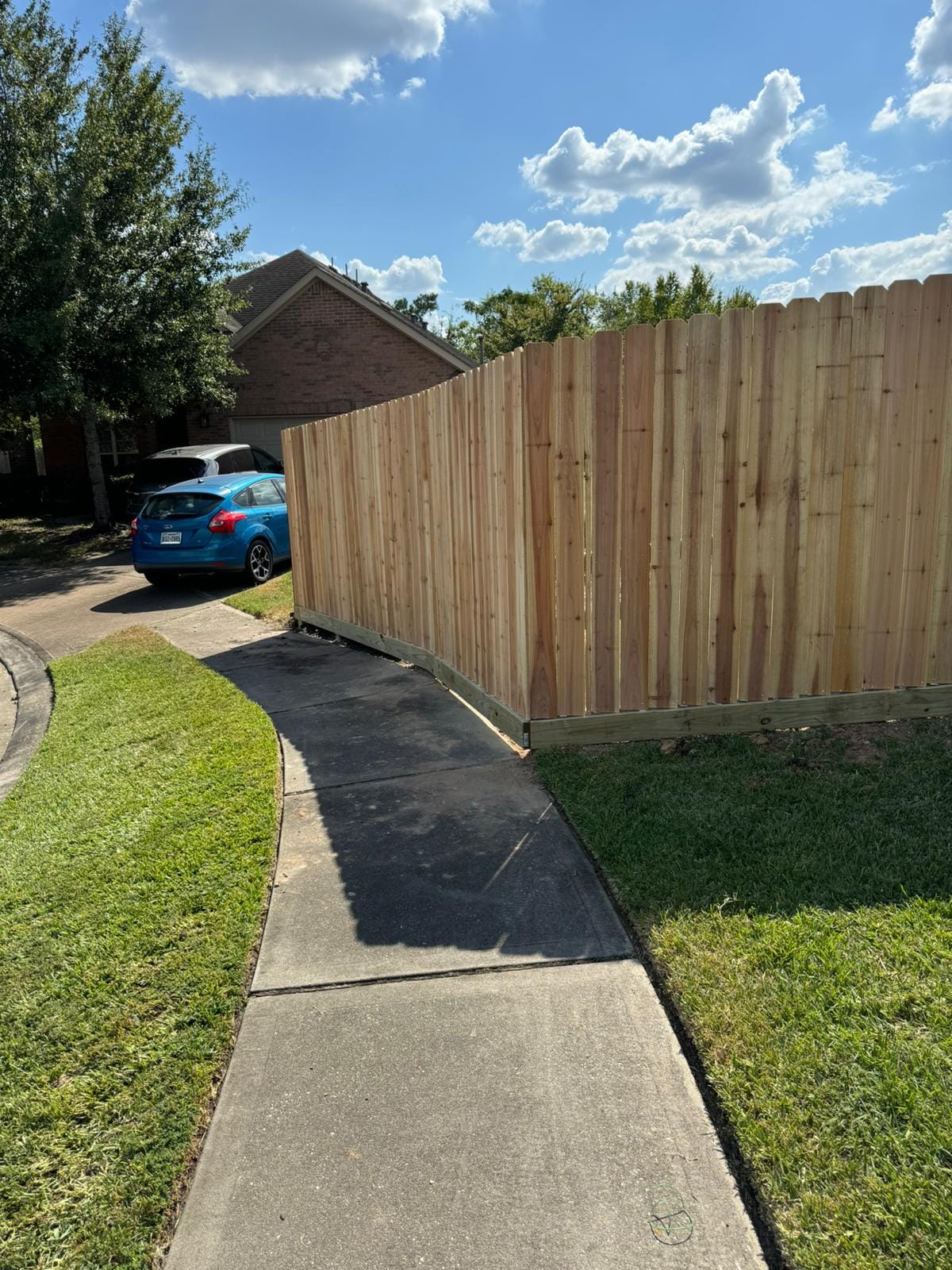 New wood privacy fence running alongside a driveway in Kemah