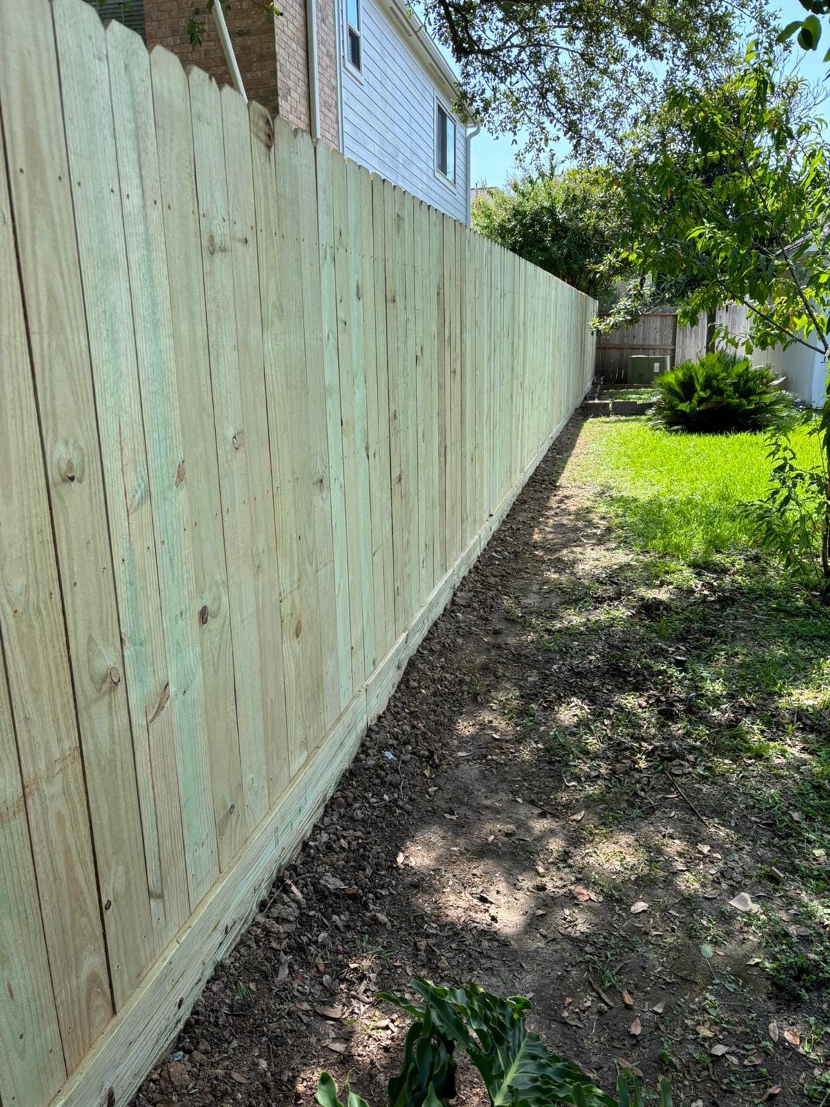 New pine privacy fence along a lawn boundary, pickets side