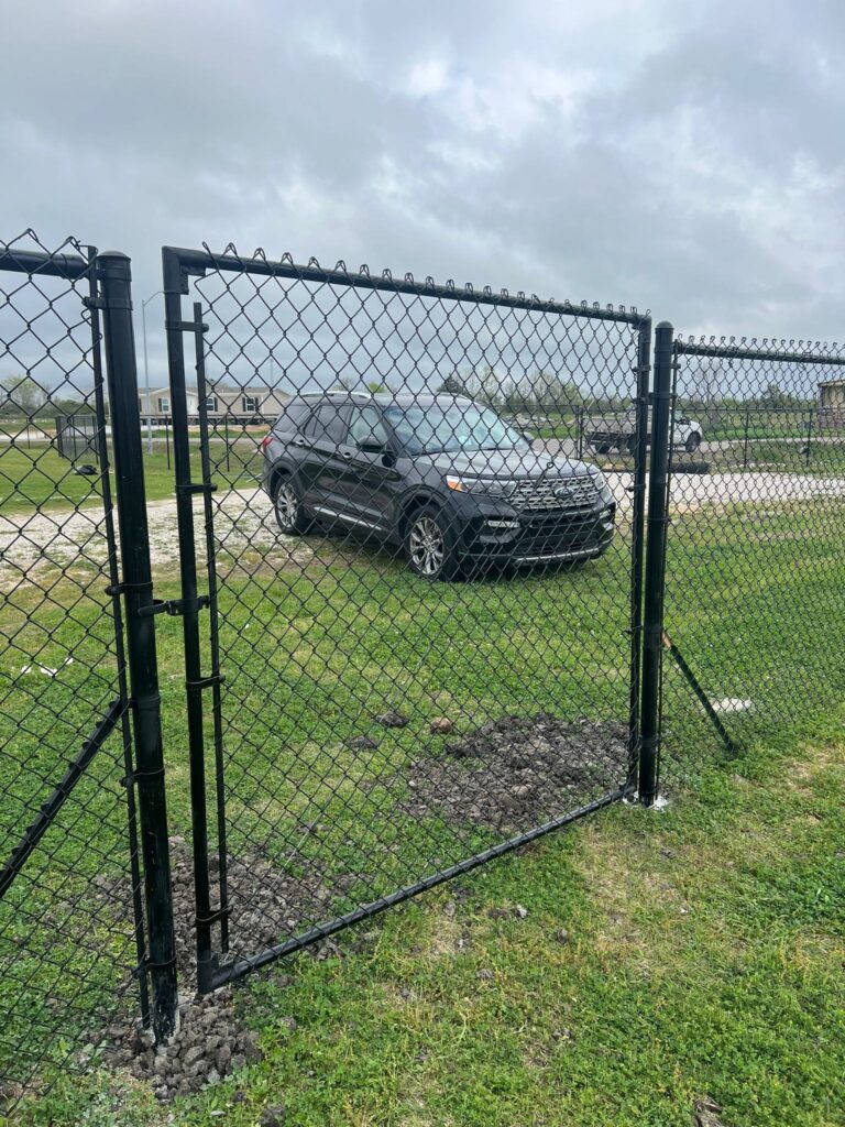 Black vinyl-coated chain link fence enclosing a residential yard