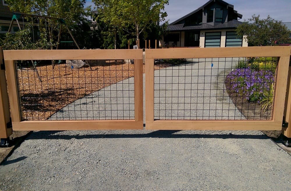 Wood-framed residential fence with wire mesh panel