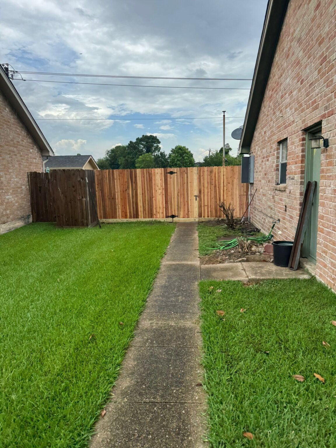 New pressure-treated wood fence, Galveston County backyard