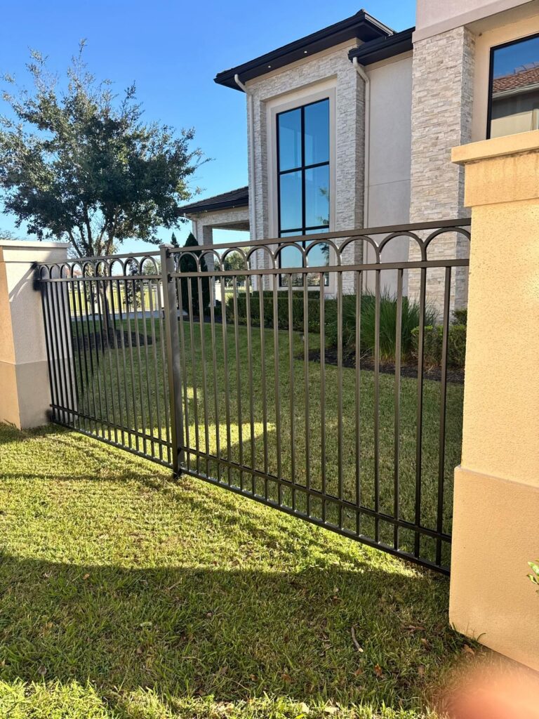 Ornamental metal fence around a residential property, a common style for pool-area barriers