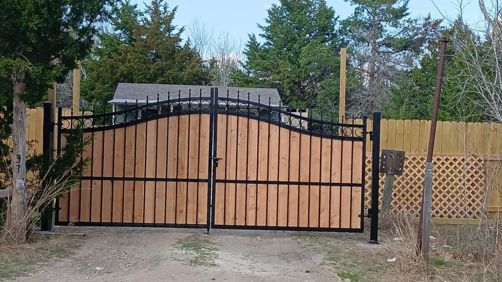 Custom wood driveway gate matching an existing wood fence line