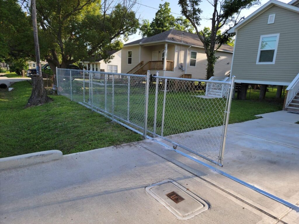 Chain link fence and gate installed along a residential yard