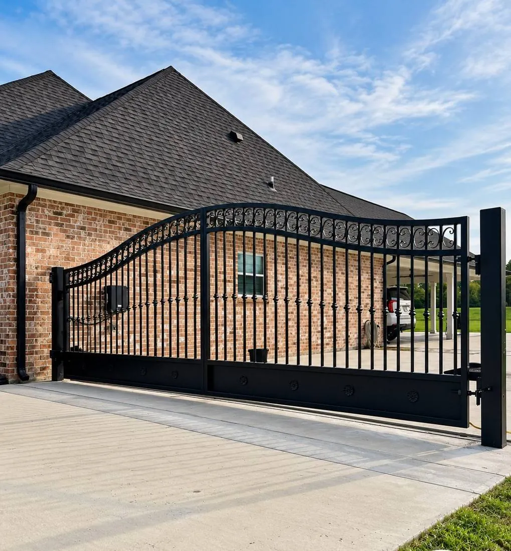 Arched black driveway gate at a brick home