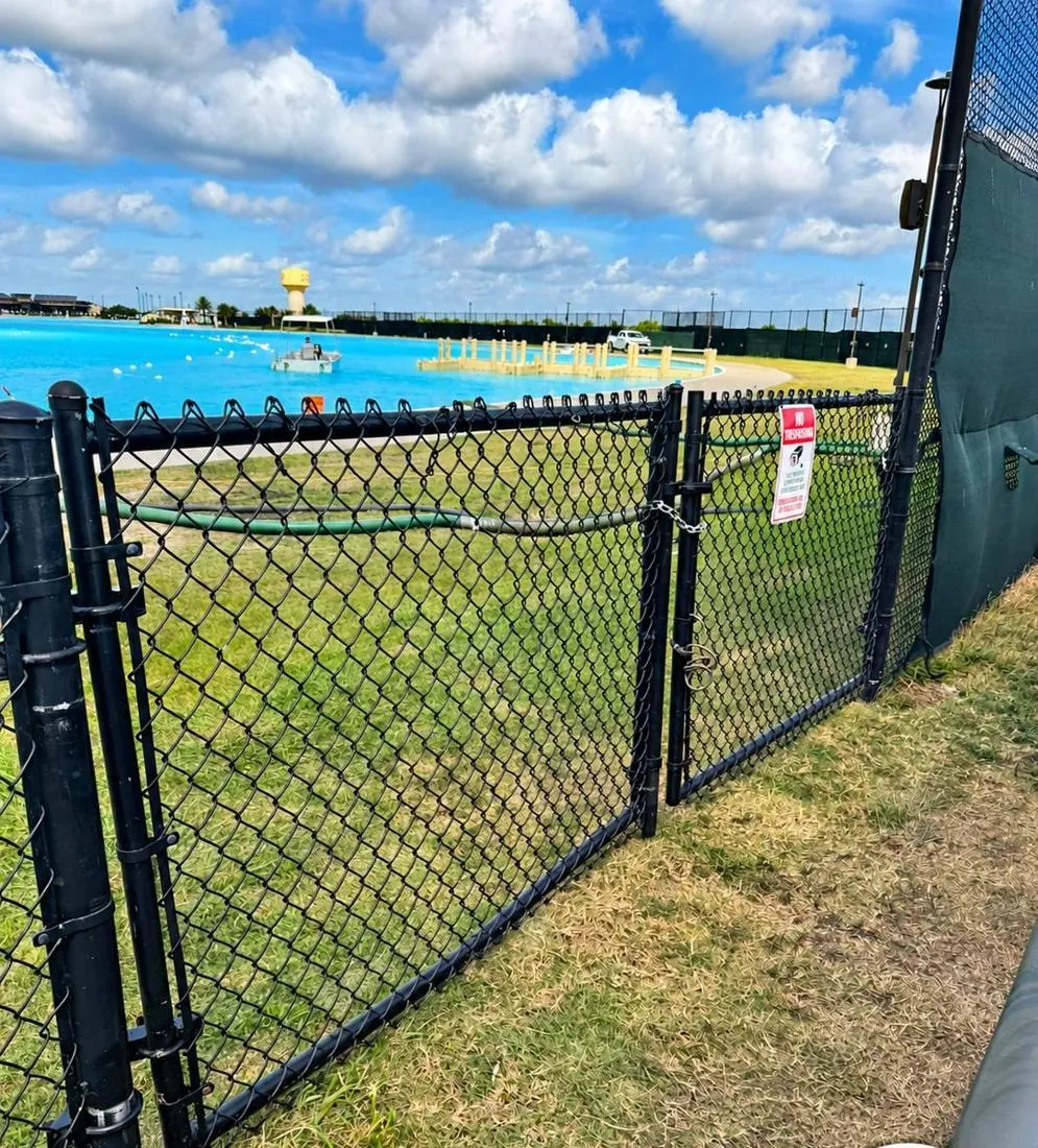 Black chain link fence and gate near a commercial yard