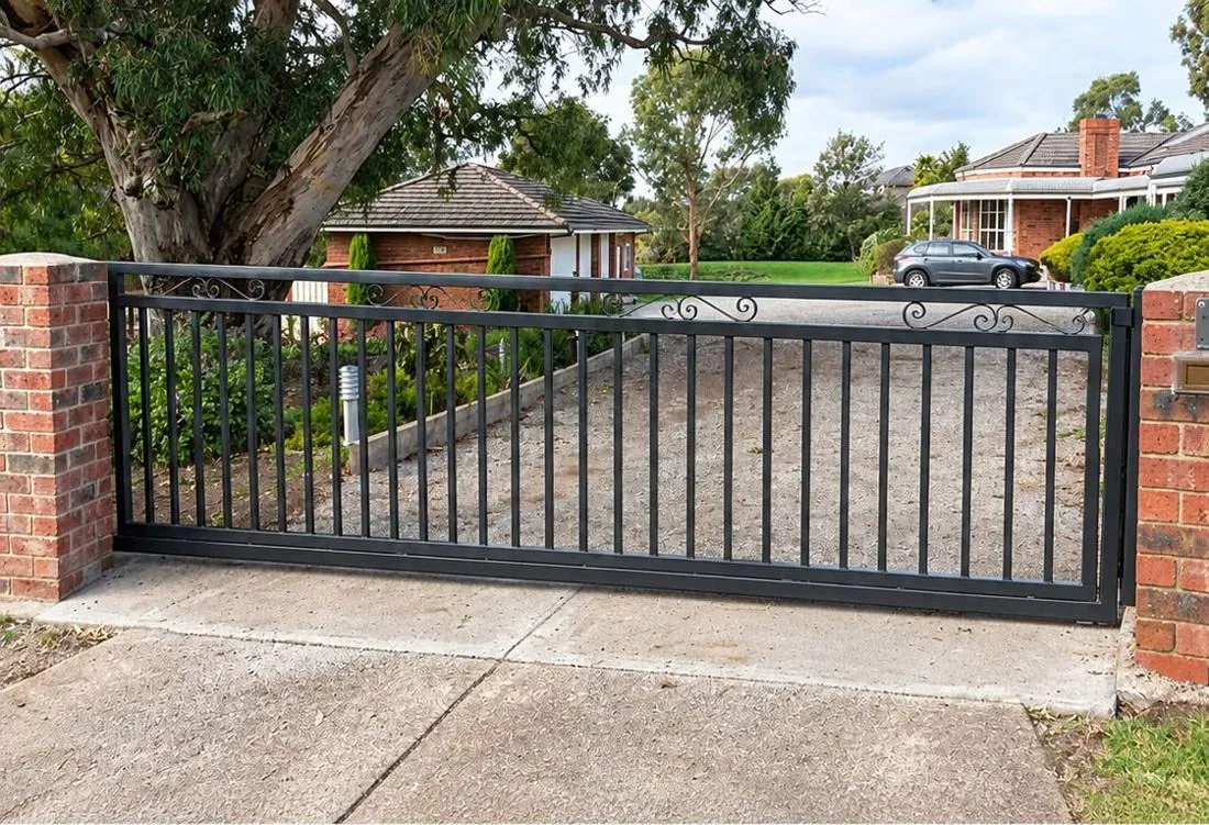 Black iron sliding gate at a brick entrance