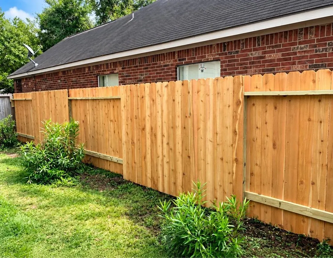 Cedar privacy fence behind a brick home