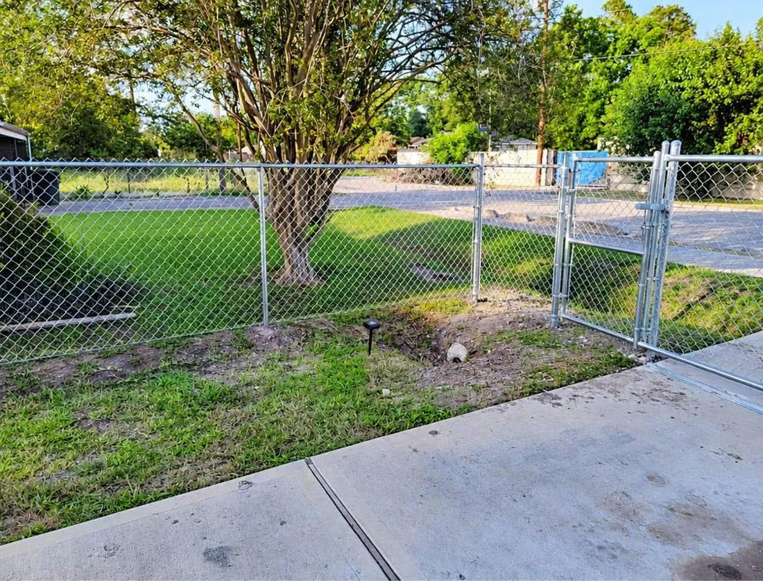 Galvanized chain link gate beside a sidewalk