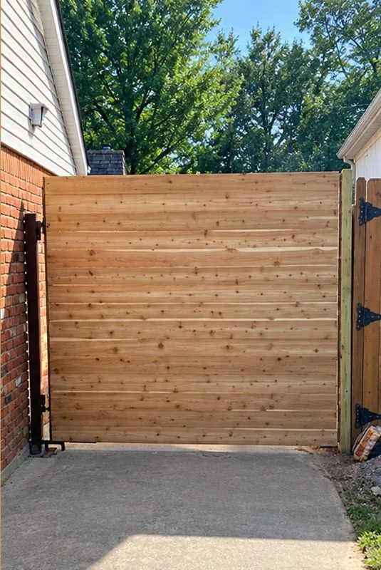After: natural horizontal cedar walk gate between brick and fence