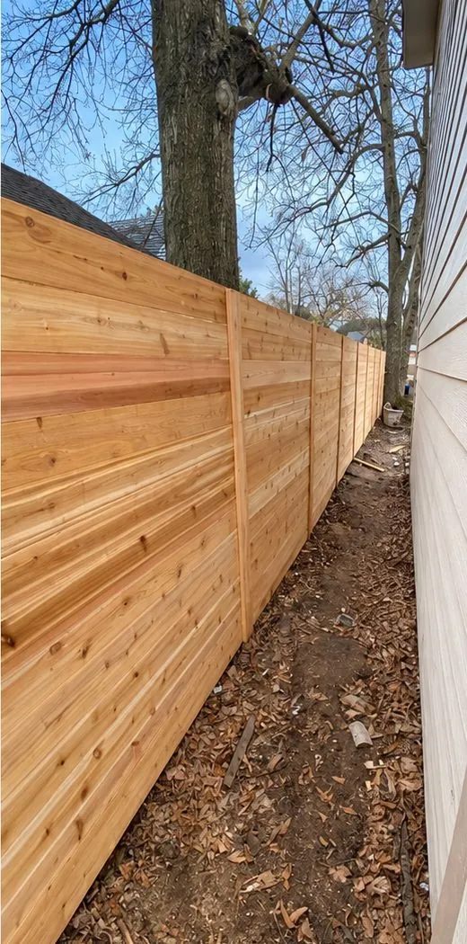 After: horizontal cedar privacy fence running down a narrow side yard